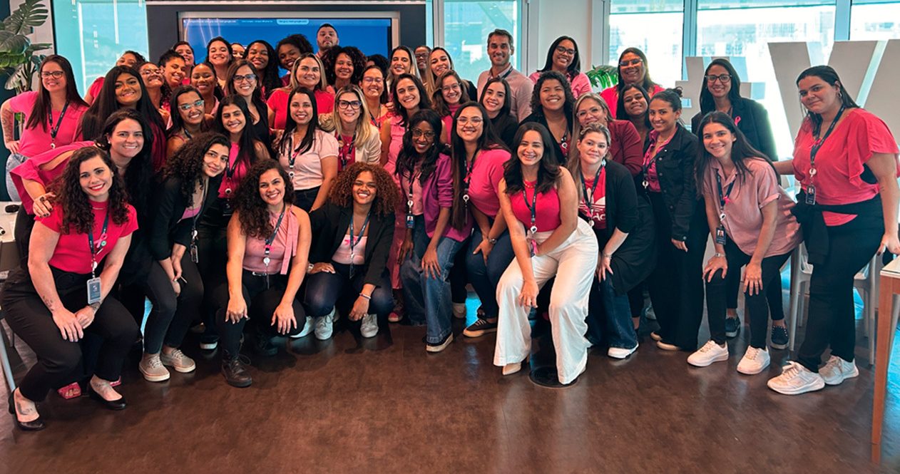 Colaboradores reunidos com a palestrante durante evento sobre o Outubro Rosa